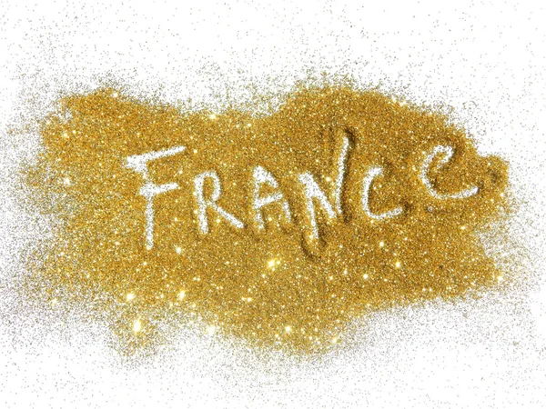 Blurry inscription France on golden glitter sparkles on white background