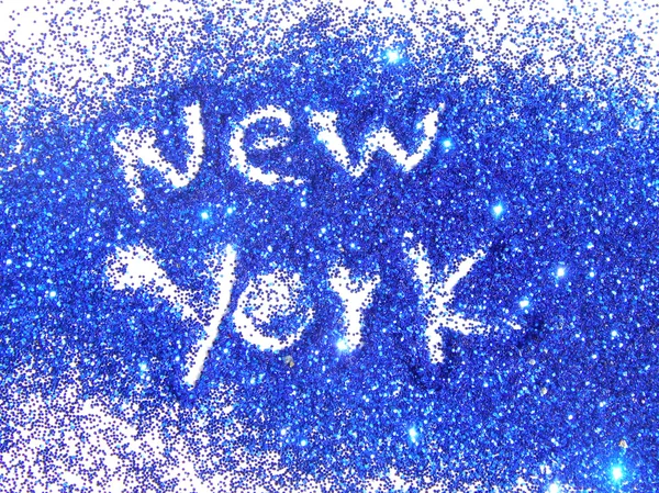 Blurry inscription New York on blue glitter sparkle on white background