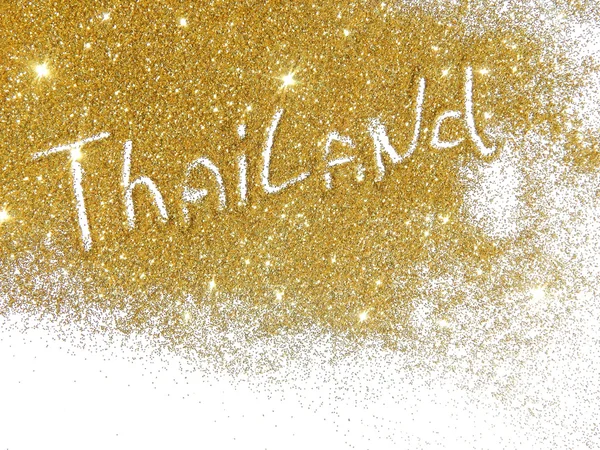 Blurry inscription Thailand on golden glitter sparkles on white background