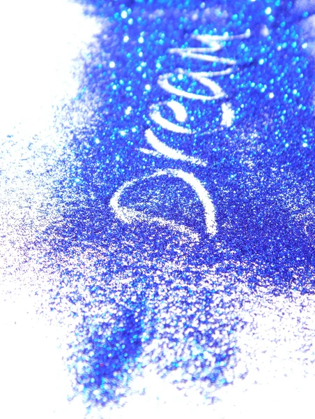 Blurry inscription Dream on dark blue glitter sparkle on white background