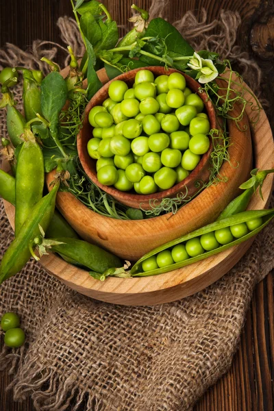 Fresh organic green peas on a wooden background.Rustic style.