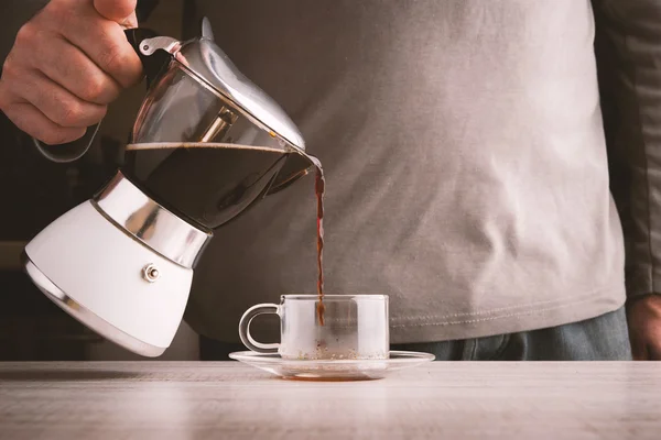 Man pouring coffee into a glass cup horizontal
