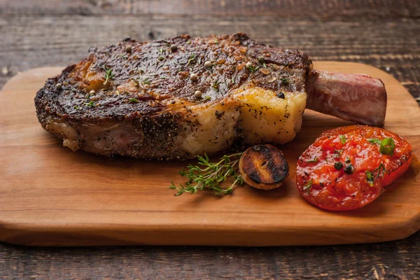 Grilled tomahawk steak on the bone on a cutting board