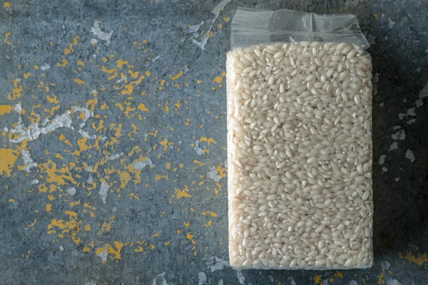 Packaging with Arborio rice on old blue background