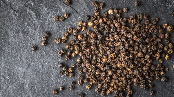 Black pepper on a background of gray slate