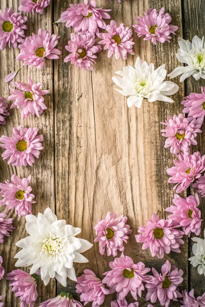 Frame of   pink  and white flower on the wooden table  vertical