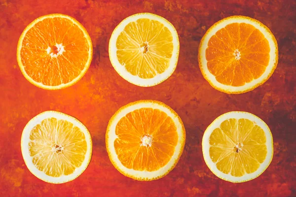 Lemon and orange slices on the terracotta background horizontal