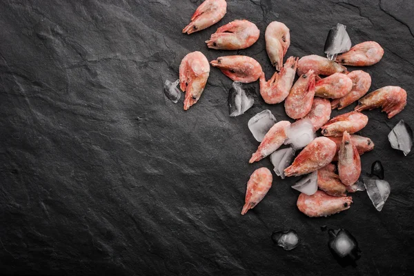 Frozen shrimps on the black stone table