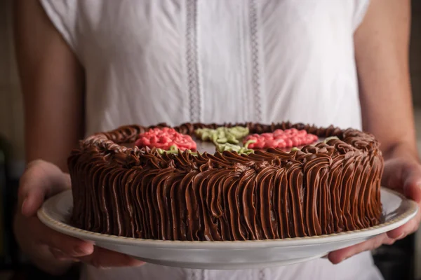 Kiev cake with chocolate cream in the woman hands horizontal