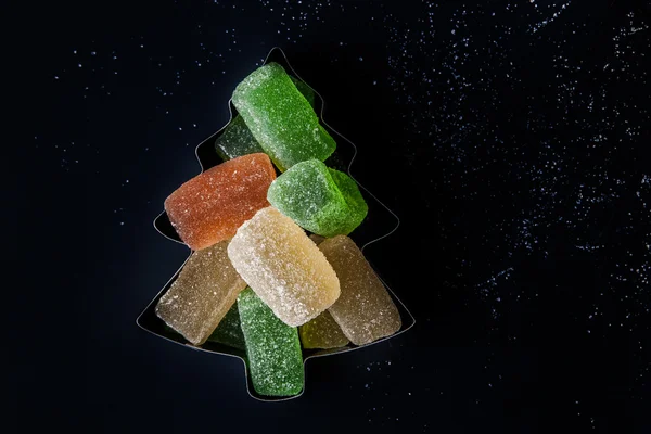 Colorful jelly Christmas tree in the forms for biscuits