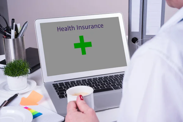 Woman looking on computer with health insurance