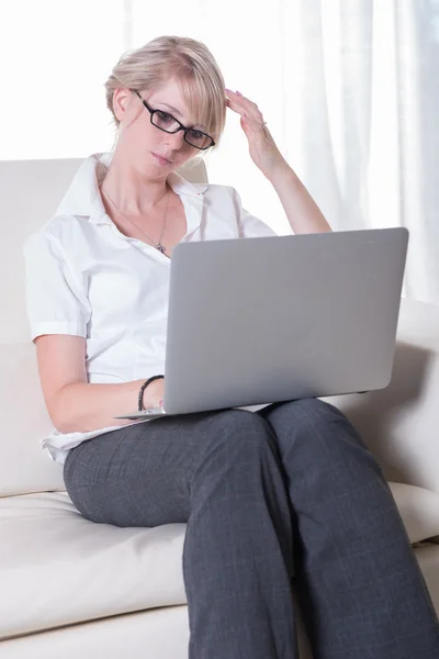 Young attractive woman working with laptop on couch