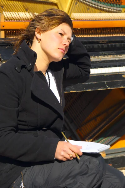 Pensive woman at the old piano