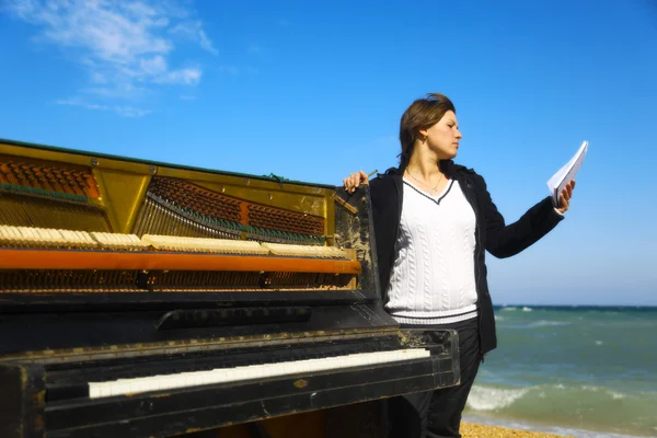 Pensive woman at the old piano