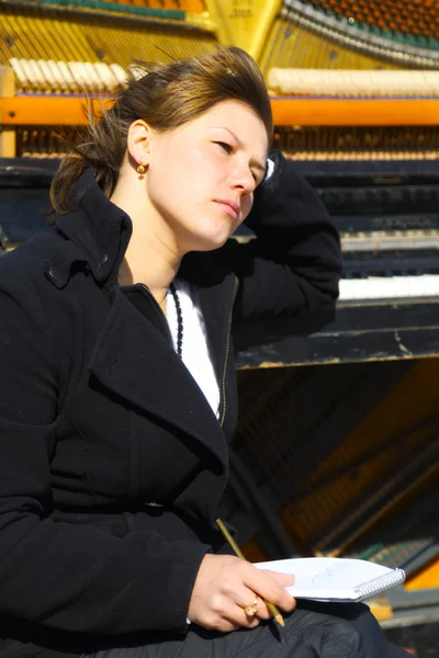 Pensive woman at the old piano