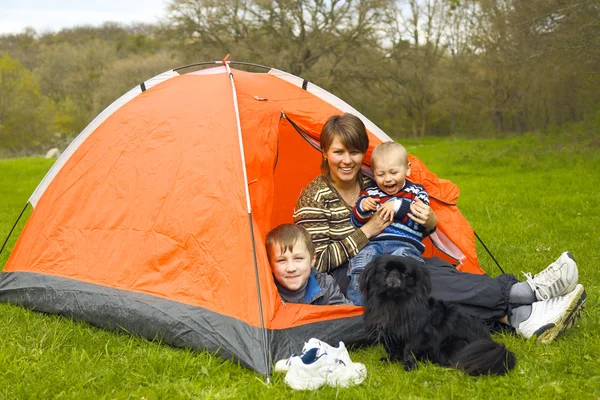 Mother with children in a tent on the nature
