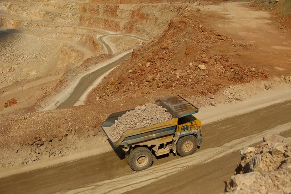 Huge trucks work in a quarry mining