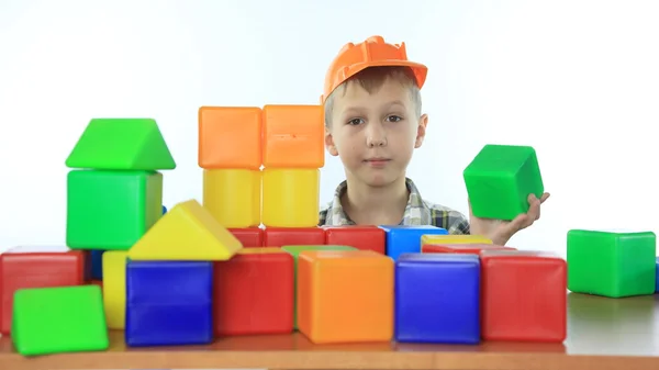 Little boy builds a house of childrens blocks