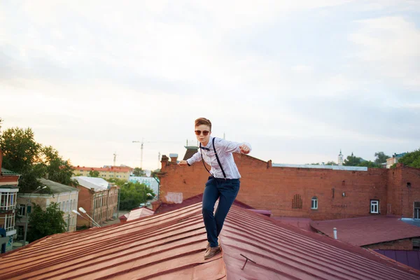 Happy hipster on the edge of the roof