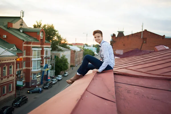 Happy hipster on the edge of the roof