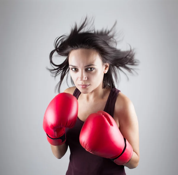 Sexy girl woman athlet in red boxing gloves kicking