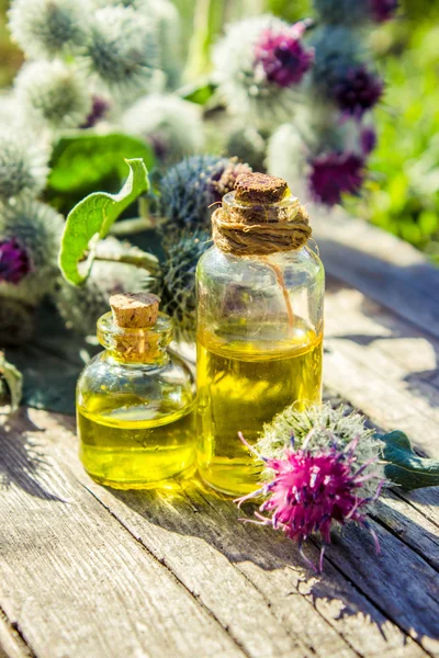 Burdock oil in a small bottle. extract, tincture, decoction, suspension, drops, herbs.