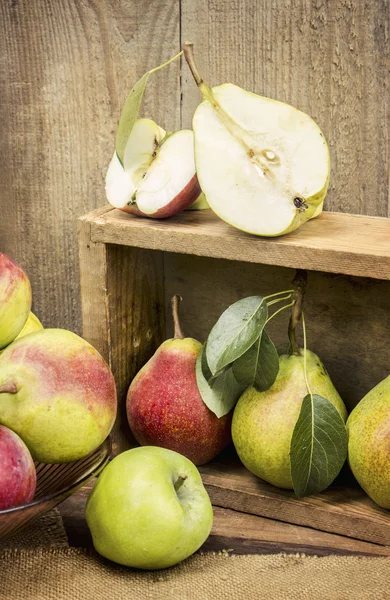 Juicy, ripe apples and pears on wooden background.