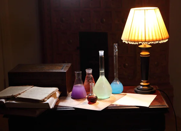 Table of the chemist, the book and flask for chemical experiment