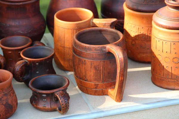 Ceramic brown mug among ceramic ware