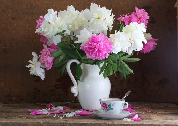 Tea and peonies, still-life with tea and a bouquet of peonies on