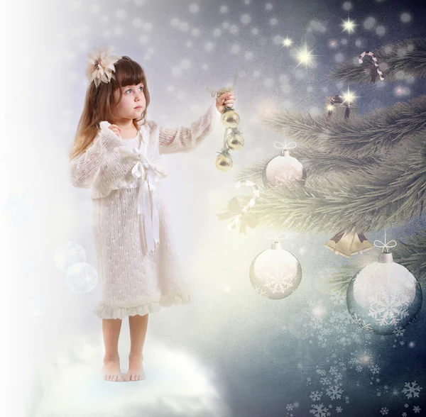 The little girl in a white dress dresses up a New Year tree