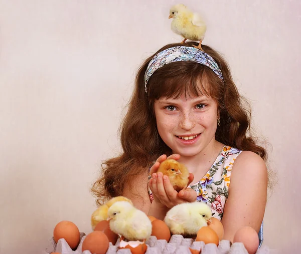 The girl plays with chickens