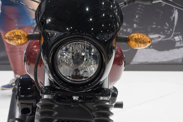 Close up of motorcycle front light, indoor photo.