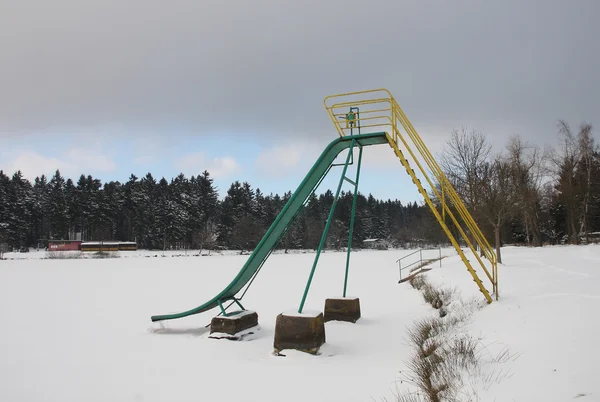 Abandoned slide on frozen lake in winter