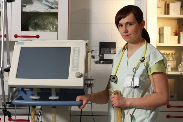 Portrait female nurse in ICU in green uniform with ventilator