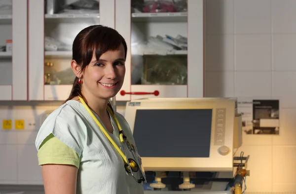 Portrait female nurse in ICU in green uniform with ventilator ma