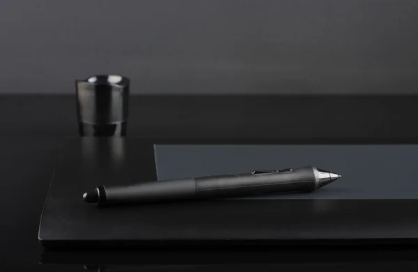 A close-up of  pen on graphic tablet on black  background