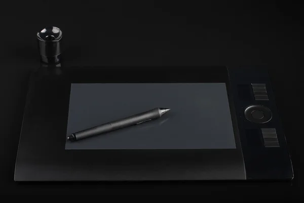 Graphic tablet and pen and stand for nibs on black  background