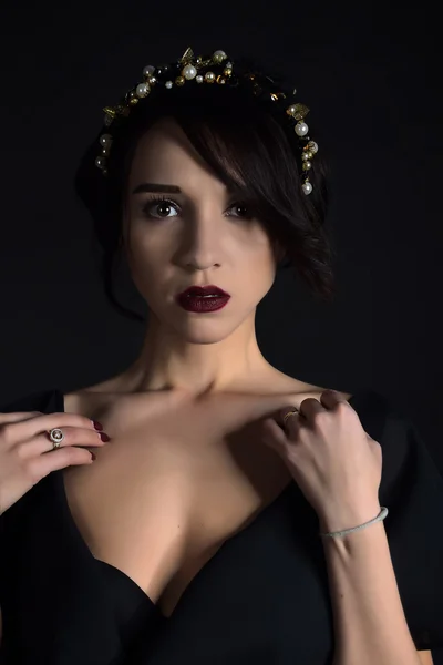 Portrait of a beautiful mysterious woman, red lipstick and collar with beads