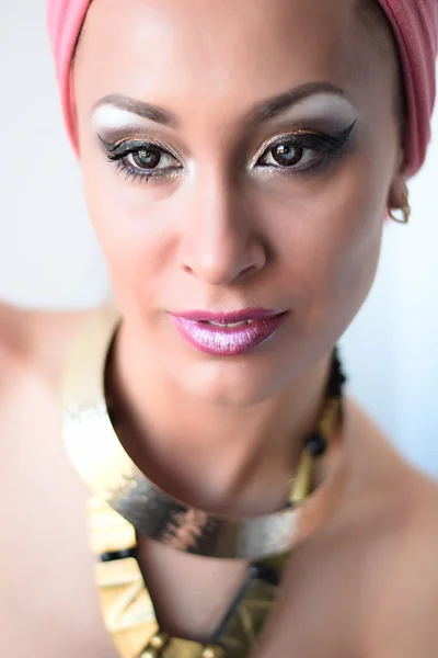 Portrait of beautiful white-skinned girl in pink turban and black dress, african queen style. White background