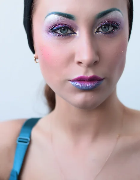 Beautiful girl with bright creative colorful fashion makeup. Art beauty design. Blue eyebrows, glitter eyeshadows and two color gradient lips