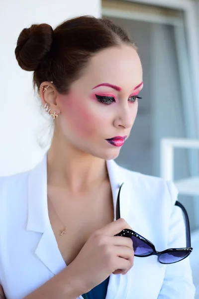 Beautiful girl with bright creative colorful fashion makeup. Art beauty design. Pink eyebrows, two color gradient lips against white