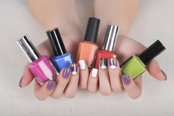 Woman hands with nail polishes and bright colorful manicure