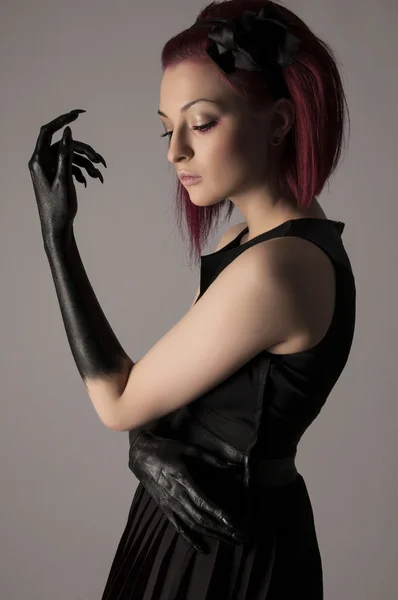 Beautiful woman with red hair and black paint on hands