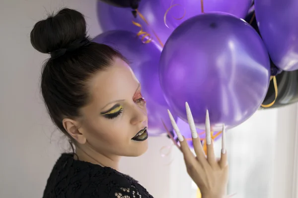 Beautiful one-eyed brunette with long nails and balloons