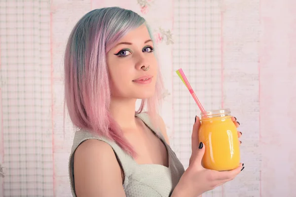Closeup portrait - happy gorgeous fashionable young woman colorful hair. Teenage girl in dress holding jar of juice.