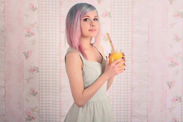 Happy gorgeous fashionable young woman colorful hair. Teenage girl in dress holding jar of juice.