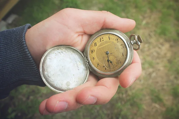 Old pocket watch in a man\'s hand