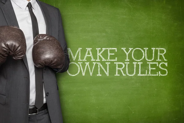Make your own rules on blackboard with businessman on side