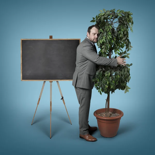 Businessman hugging a tree at office